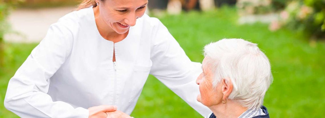 enfermera dando la mano a una anciana